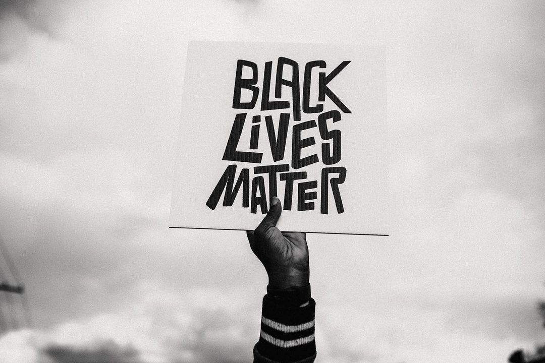 Hand in the air holding a Black Lives Matter sign